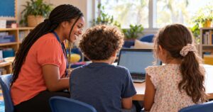 Smiling teacher beside two 4th graders working on a Chromebook during FAST 4th grade math test prep